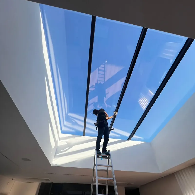 Limpeza de uma grande claraboia de vidro no interior de uma habitação
